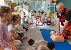 Dzieci patrzą jak ratownik medyczny pokazuje fantoma.