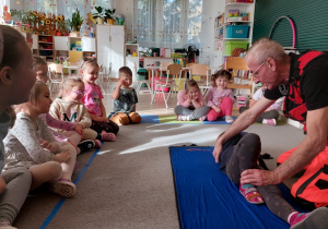 Ratownik medyczny pokazuje bezpieczną pozycję boczną.