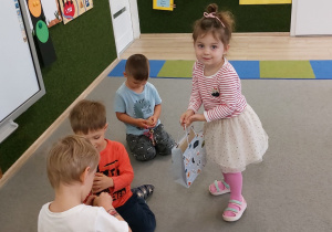 Dziewczynka wręcza chłopcu prezent.