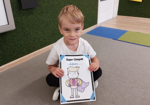 Chłopiec pokazuje dyplom.