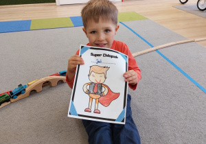 Chłopiec pokazuje dyplom.