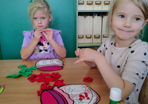 Dziewczynka wykleja pracę bibułą.