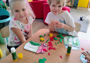 Dzieci wyklejają pracę bibułą.