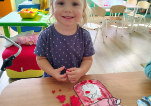 Dzieci wyklejają pracę bibułą.