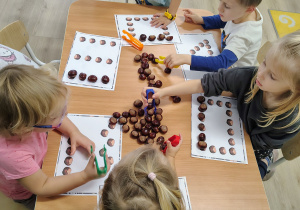 Dzieci układają kasztany.