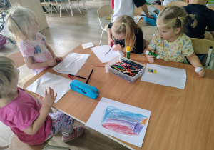 Dzieci rysują przy stoliczku.