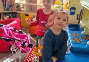 Dziewczynki bawią się w kąciku kuchennym.