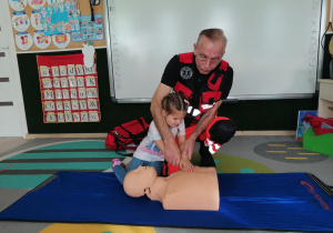 Dziewczynka uciska manekina.