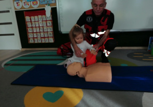 Dziewczynka uciska manekina.