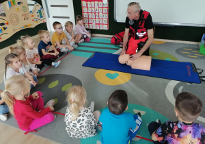 Ratownik pokazuje jak odchylać głowę.