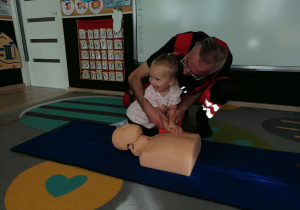 Dziewczynka uciska manekina.