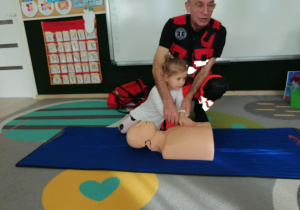 Dziewczynka uciska manekina.