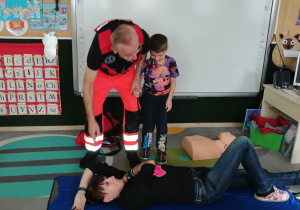 Chłopiec podchodzi do osoby poszkodowanej.