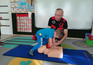 Chłopiec uciska manekina.