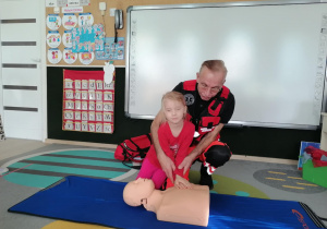 Dziewczynka uciska manekina.