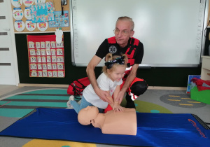 Dziewczynka uciska manekina.