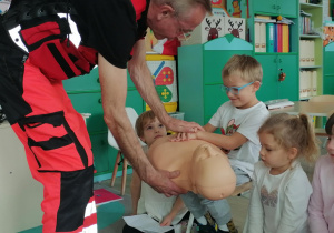 Dzieci dotykają manekina.