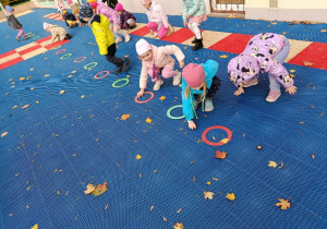 Dzieci bawią się kasztanami na tarasie.