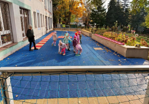 Dzieci bawią się kasztanami na tarasie.