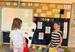 Dziewczynka przed tekturowym zębem.