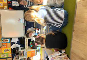 Nauczycielka pokazuje na modelu zęba technikę mycia.