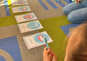 Na dywanie instrukcja z planszami "Myjemy zęby".