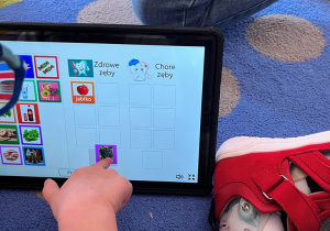 Chłopiec wykonuje zadanie na tablecie "Zdrowy i chory ząb".