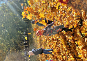 Dzieci podzrzucają liście.