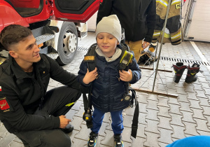 Dziecko z plecakiem strażaka.