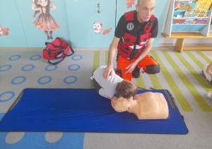 Dziecko sprawdza na fantomie czy osoba jest przytomna.