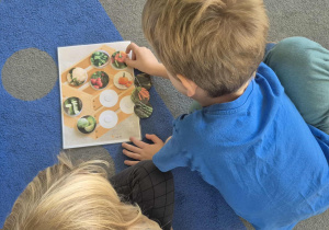 Dzieci przyczepiają ilustracje warzyw.