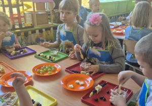 Dzieci jedzą mus owocowy.