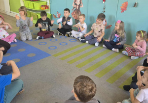 Dzieci powtarzają ruchy za nauczycielką.