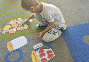 Chłopiec układa warzywa.