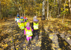 Dzieci idą przez park.