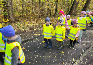 Dzieci idą przez park.