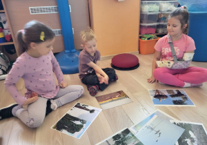 Dzieci oglądają zdjęcia bocianów.