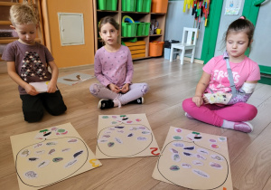 Dzieci układają co jedzą bociany.