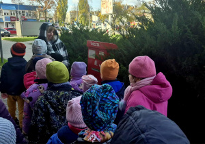 Dzieci oglądają skrzynkę pocztową.