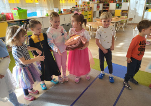 Dzieci podają sobie balon.