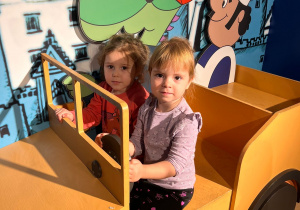 Dziewczynki pozują do zdjęcia w samochodzie.