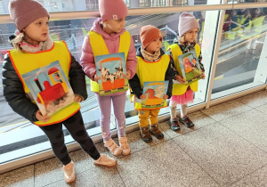 Dzieci trzymają ilustracje.