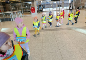 Dzieci idą w kole, trzymają ilustracje.