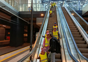 Dzieci jadą ruchomymi schodami.