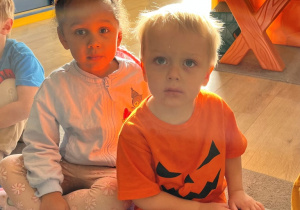 Dzieci w pomarańczowych strojach.