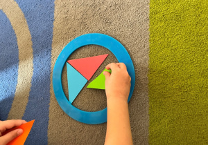 Dziecko układa w kole trójkaty.