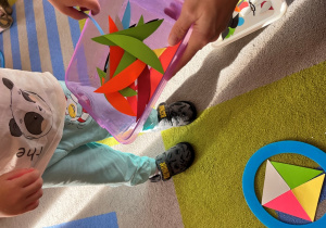 Dziecko układa w kole trójkaty.