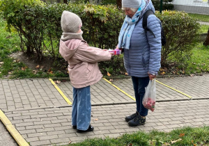 Dziewczynka wręcza pani herbatkę.