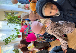 Dzieci wręczja herbatę seniorom.