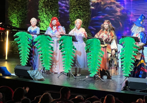 Aktorzy śpiewają piosenki na deskach teatru.